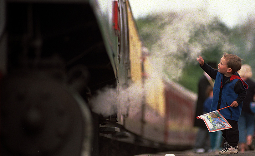 Small boy waving at train on Avon Valley Railway platform